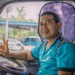Een buschauffeur van Connexxion rijdt een bus door de stad, met een focus op klantvriendelijkheid en veilig vervoer.