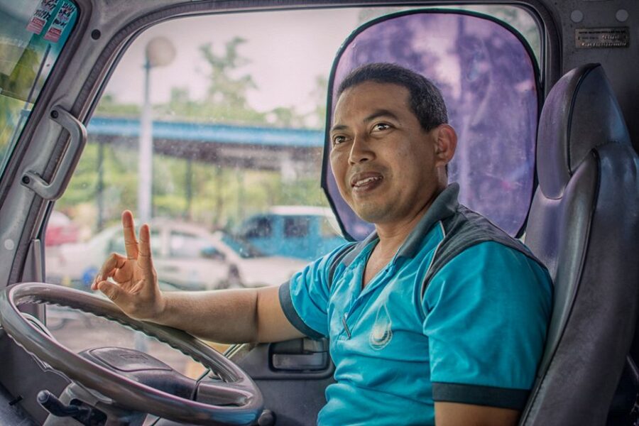 Een buschauffeur van Connexxion rijdt een bus door de stad, met een focus op klantvriendelijkheid en veilig vervoer.