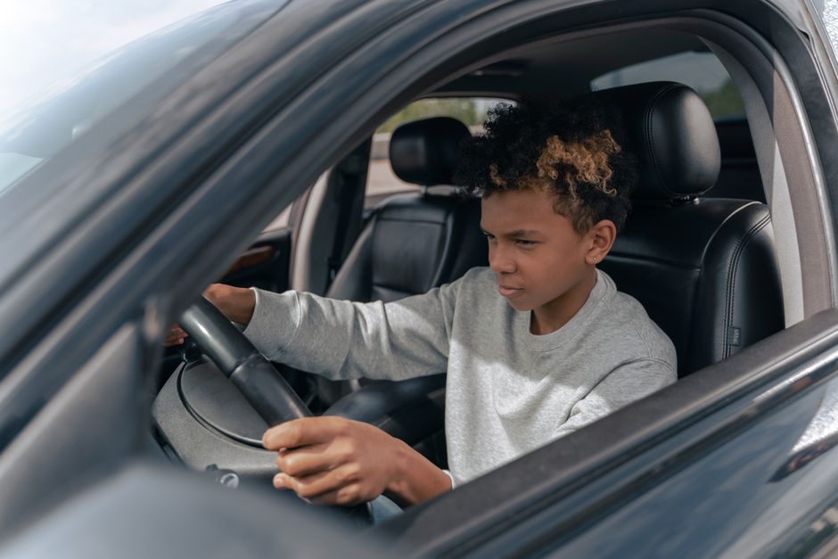 Jongeman die zich voorbereidt op het halen van zijn auto rijbewijs met een instructeur in de auto.