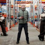 Een team logistiek medewerkers die samenwerken in een magazijnomgeving, gericht op efficiëntie en teamwork.