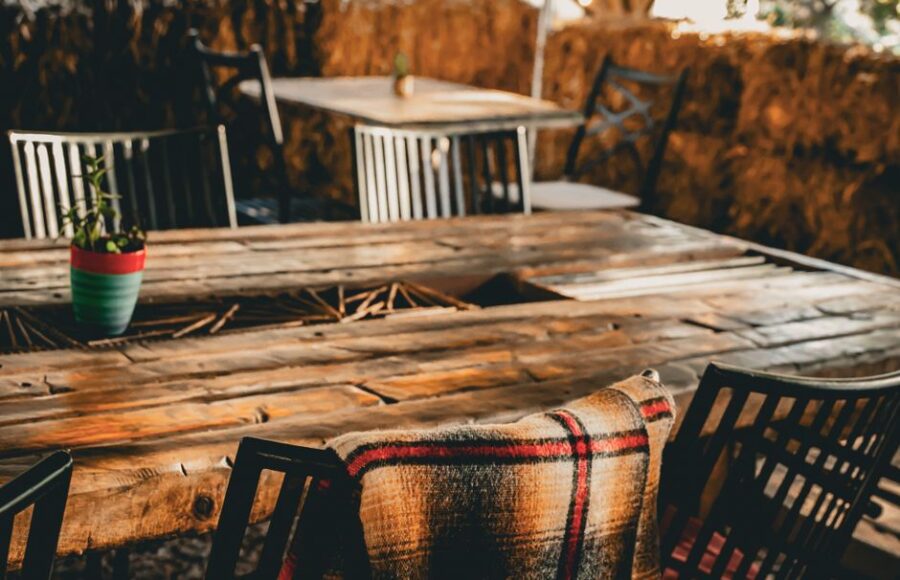 Maatwerk houten tafel in een modern interieur met stoelen en decoratie.