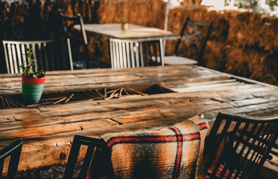 Maatwerk houten tafel in een modern interieur met stoelen en decoratie.